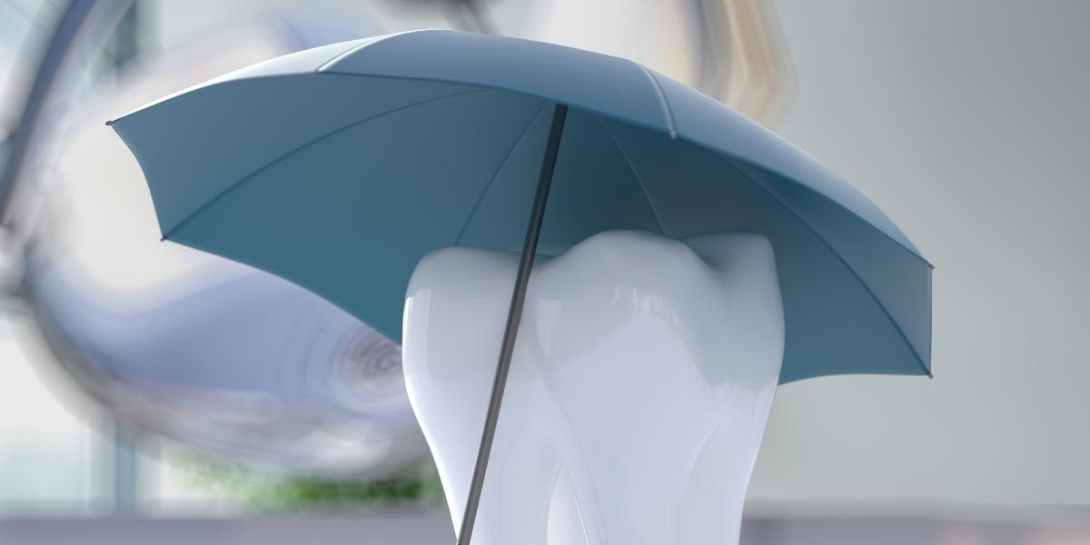 Tooth with an umbrella over it representing dental insurance coverage