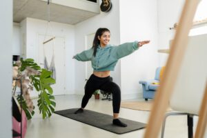 A young woman smiling while doing yoga, symbolizing the connection between oral health and overall wellness, as promoted by Sierra Smiles Complete Health Dentistry.